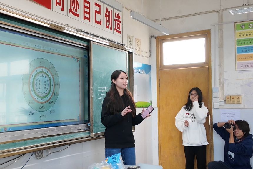 A teacher presenting the Nutrition Week programme on a classroom projector while students stand at the front