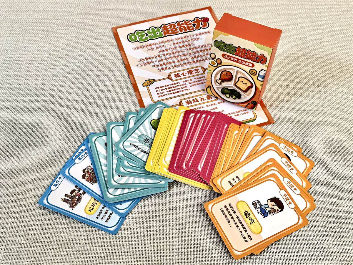 A fan of NutriEmpower food cards spread out next to the game manual