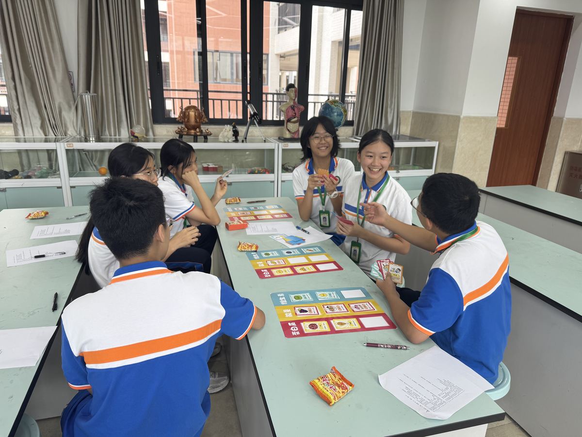 Students in school uniform playing the NutriEmpower card game around a classroom table